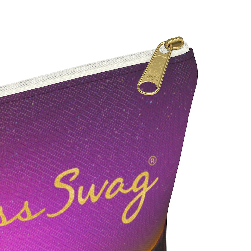 Goddess Swag Bag Mini (named cosmic).  Item can be used as accessory pouch, makeup bag or cosmetic bag with a background is purple with some orange like sunset.  Goddess Swag wording is in gold on one side of the bag only.  There is an option of a black or a white zipper, and a large or a small bag. 