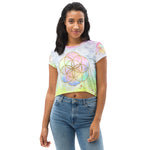 Load image into Gallery viewer, short sleeve crop top tee shirt pastel tie dye background with seed of life design in gold  on front.  Left sleeve has a hexagon and right has a star tetrahedron symbol.
