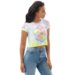 Load image into Gallery viewer, short sleeve crop top tee shirt pastel tie dye background with seed of life design in gold  on front.  Left sleeve has a hexagon and right has a star tetrahedron symbol.
