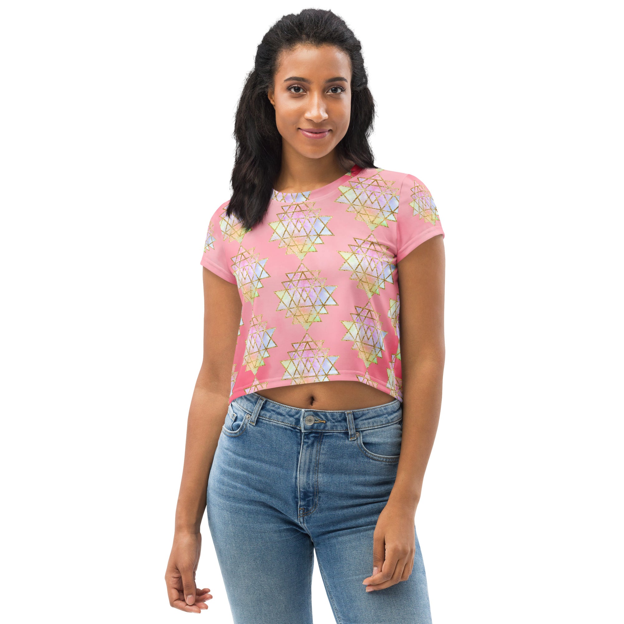 Light to medium pink background with pastel and gold color sri yantra design all over front back and short sleeves.  This is a crop top tee by goddess swag as part of the cosmic powers collection