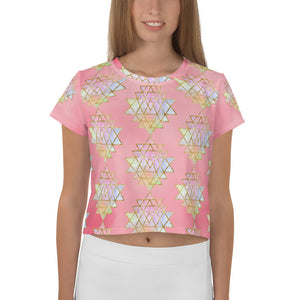 Light to medium pink background with pastel and gold color sri yantra design all over front back and short sleeves.  This is a crop top tee by goddess swag as part of the cosmic powers collection