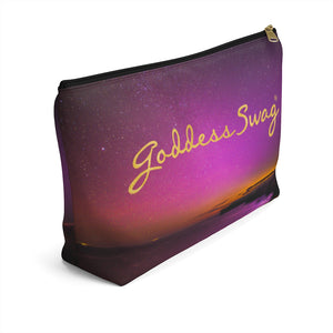 Goddess Swag Bag Mini (named cosmic).  Item can be used as accessory pouch, makeup bag or cosmetic bag with a background is purple with some orange like sunset.  Goddess Swag wording is in gold on one side of the bag only.  There is an option of a black or a white zipper, and a large or a small bag. 