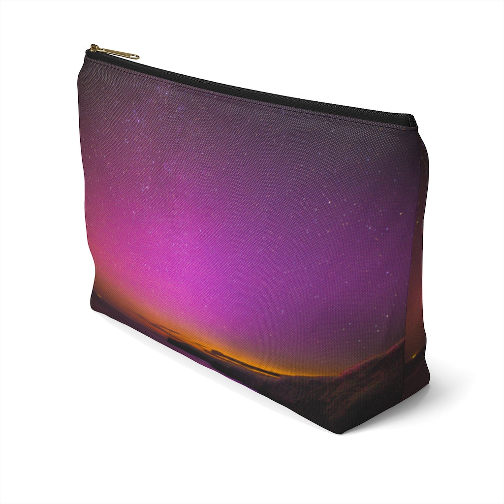 Goddess Swag Bag Mini (named cosmic).  Item can be used as accessory pouch, makeup bag or cosmetic bag with a background is purple with some orange like sunset.  Goddess Swag wording is in gold on one side of the bag only.  There is an option of a black or a white zipper, and a large or a small bag. 