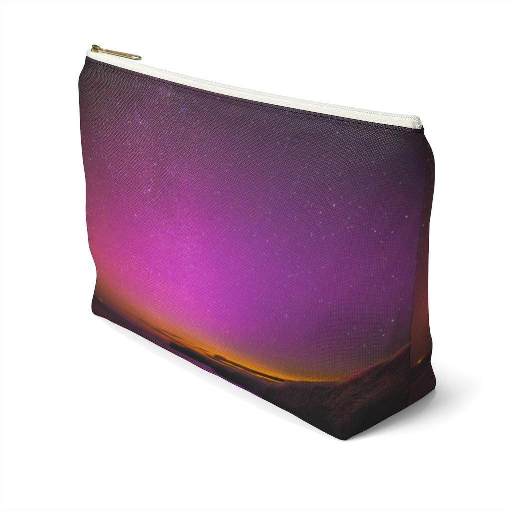 Goddess Swag Bag Mini (named cosmic).  Item can be used as accessory pouch, makeup bag or cosmetic bag with a background is purple with some orange like sunset.  Goddess Swag wording is in gold on one side of the bag only.  There is an option of a black or a white zipper, and a large or a small bag. 