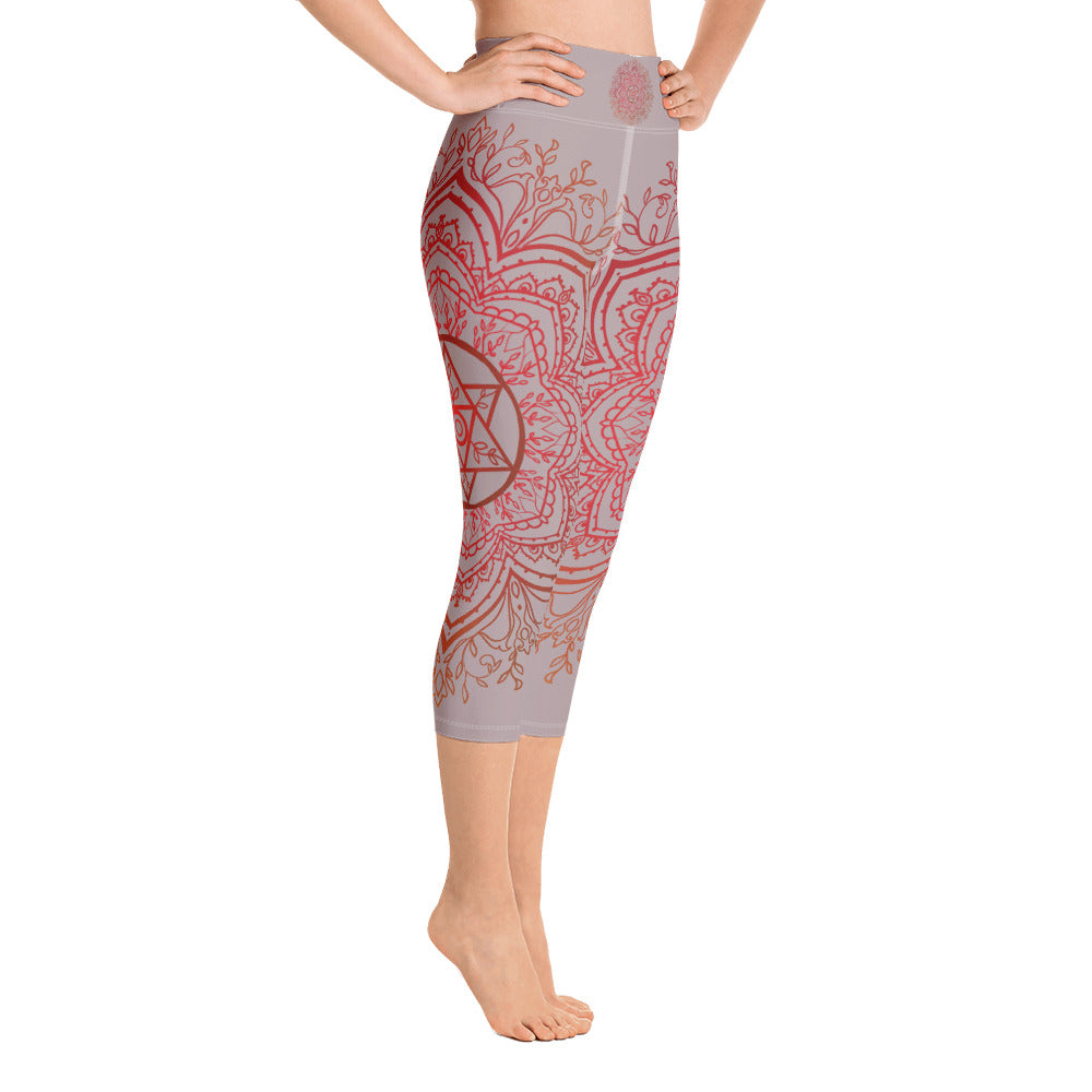 Yoga capri leggings midcalf length by Goddess Swag.  Background solid color is a medium grey. design overlay in front and back is a red mandala print for the earth star chakra.  On front waist is the earth star chakra centered. On back waist is goddess swag written out in red.