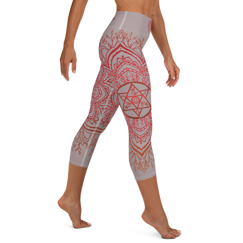 Yoga capri leggings midcalf length by Goddess Swag.  Background solid color is a medium grey. design overlay in front and back is a red mandala print for the earth star chakra.  On front waist is the earth star chakra centered. On back waist is goddess swag written out in red.