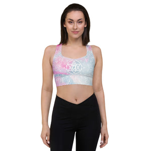ethereal heart chakra mandala llongline sports bra by goddess swag. main colors are pastel pinks and blues. the design overlay on front and back is a white heart chakra mandala design. goddess swag is written on the back in sanskrit style writing
