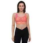 Load image into Gallery viewer, longline sports bra by goddess swag. the design has a pink orange background with an overlay of a root chakra mandala design in red and orange. this design is on front and back of sports bra.
