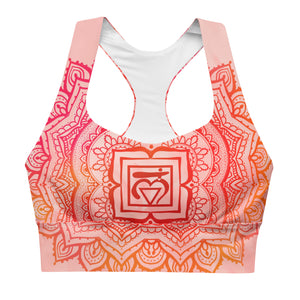 longline sports bra by goddess swag. the design has a pink orange background with an overlay of a root chakra mandala design in red and orange. this design is on front and back of sports bra.