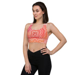 Load image into Gallery viewer, longline sports bra by goddess swag. the design has a pink orange background with an overlay of a root chakra mandala design in red and orange. this design is on front and back of sports bra.
