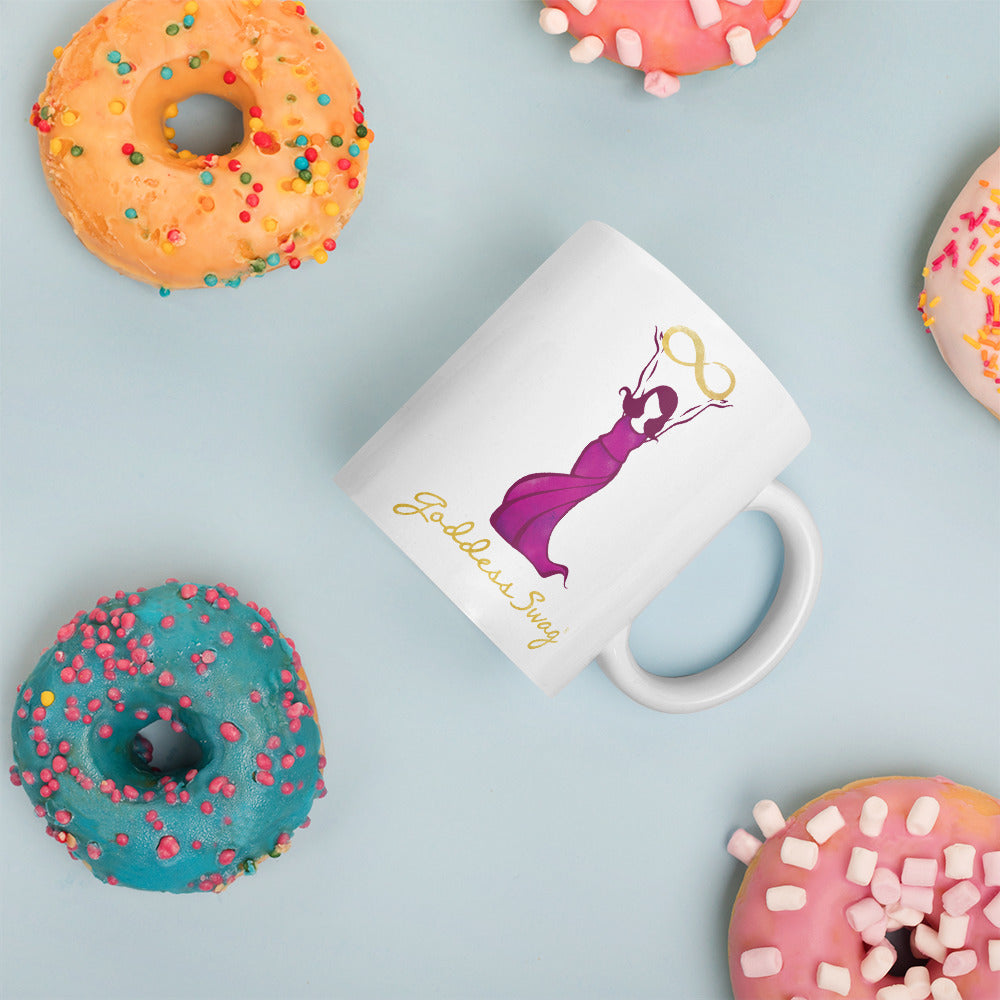 Goddess Swag Signature Logo Ceramic Coffee Mug 11oz with goddess holding  a gold infinity design above her head.  Her dress is magenta.  Goddess Swag is written ion gold.