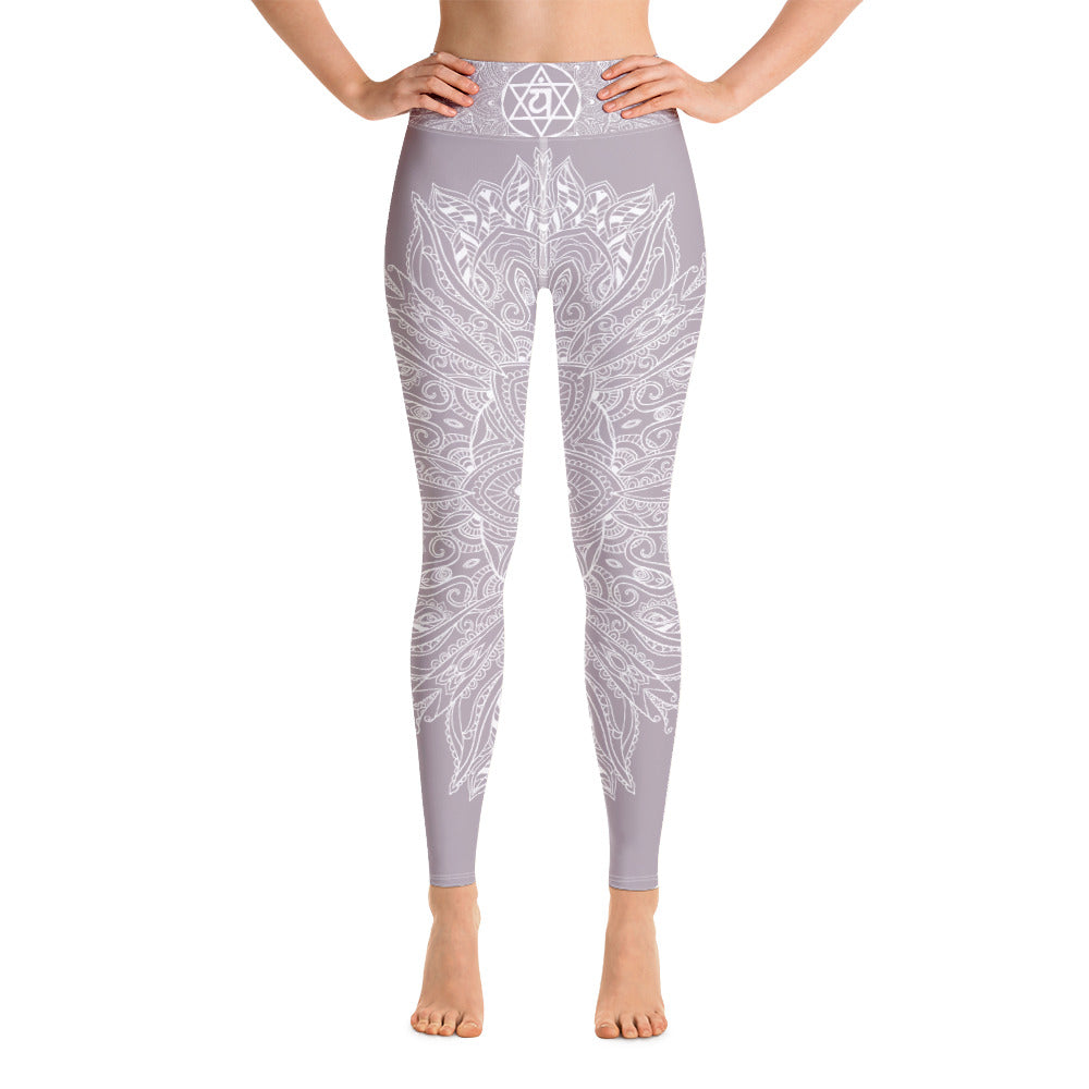 full length yoga legging from collection mystic mandala by goddess swag.  the design is a heart chakra symbol and mandala blown out on the front and back in white.  The front waistband has the 6 pointed star chakra design and the back waistband has goddess swag written. The background color os a solid light mauve gray.