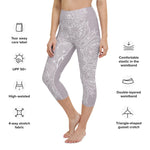 Load image into Gallery viewer, mystic-77-heart-chakra-mandala-capri-leggings-by-goddess-swag.  Background color is a light to medium mauve.  The mandala design is white and all over front and back. Goddess Swag is written on the back waistband in sanskrit style in a deep purple.
