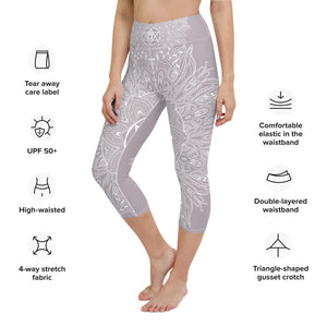 mystic-77-heart-chakra-mandala-capri-leggings-by-goddess-swag.  Background color is a light to medium mauve.  The mandala design is white and all over front and back. Goddess Swag is written on the back waistband in sanskrit style in a deep purple.