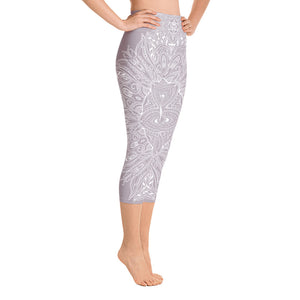 mystic-77-heart-chakra-mandala-capri-leggings-by-goddess-swag.  Background color is a light to medium mauve.  The mandala design is white and all over front and back. Goddess Swag is written on the back waistband in sanskrit style in a deep purple.