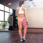Load image into Gallery viewer, Full length leggings. Coloring is light pink, orange and red for the root chakra, front and back.  the waist band has the root chakra mandala design.  the back waist band has goddess swag written in sanskrit style font. Designed by goddess swag.
