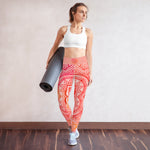 Load image into Gallery viewer, Full length leggings. Coloring is light pink, orange and red for the root chakra, front and back.  the waist band has the root chakra mandala design.  the back waist band has goddess swag written in sanskrit style font. Designed by goddess swag.
