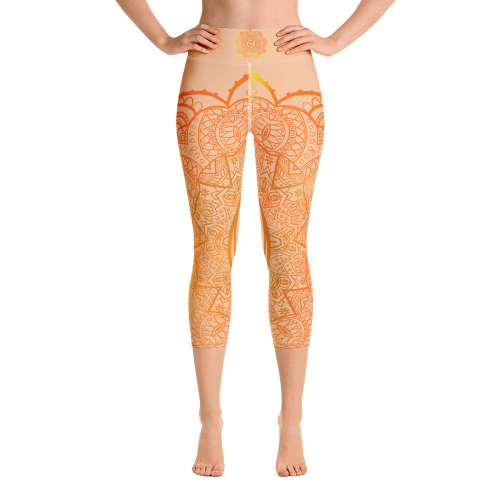 yoga capri leggings by goddess swag. Design is a sacral chakra mandala on front and back of leggings in deep orange and light yellow coloring.  Back waist has goddess swag written in light gold. mid calf legging length.