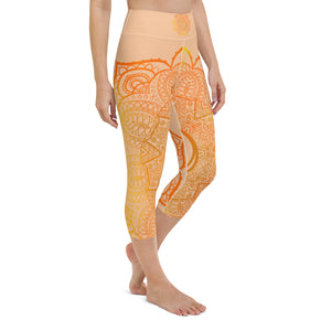 yoga capri leggings by goddess swag. Design is a sacral chakra mandala on front and back of leggings in deep orange and light yellow coloring.  Back waist has goddess swag written in light gold. mid calf legging length.