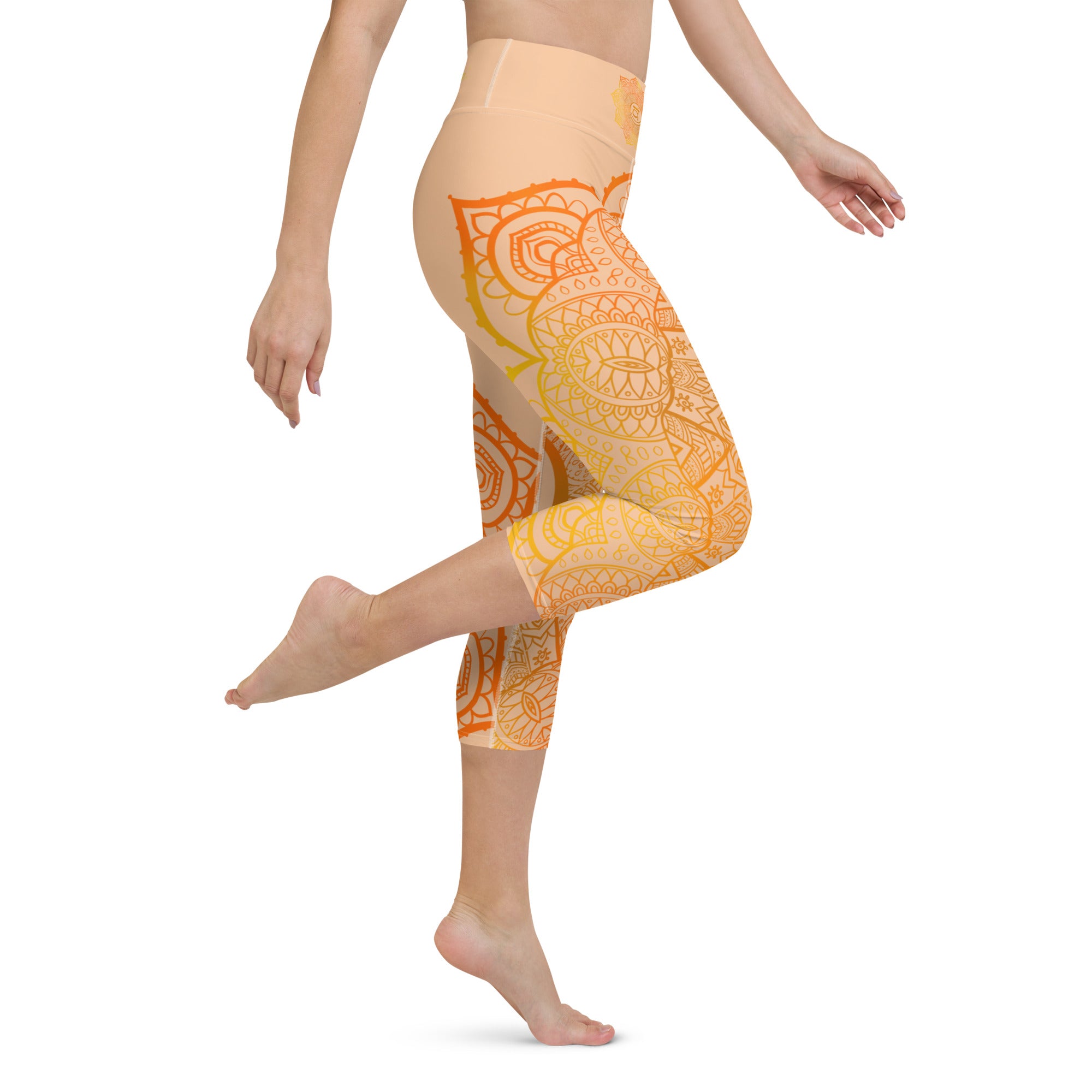 yoga capri leggings by goddess swag. Design is a sacral chakra mandala on front and back of leggings in deep orange and light yellow coloring.  Back waist has goddess swag written in light gold. mid calf legging length.