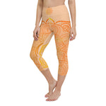 Load image into Gallery viewer, yoga capri leggings by goddess swag. Design is a sacral chakra mandala on front and back of leggings in deep orange and light yellow coloring.  Back waist has goddess swag written in light gold. mid calf legging length.
