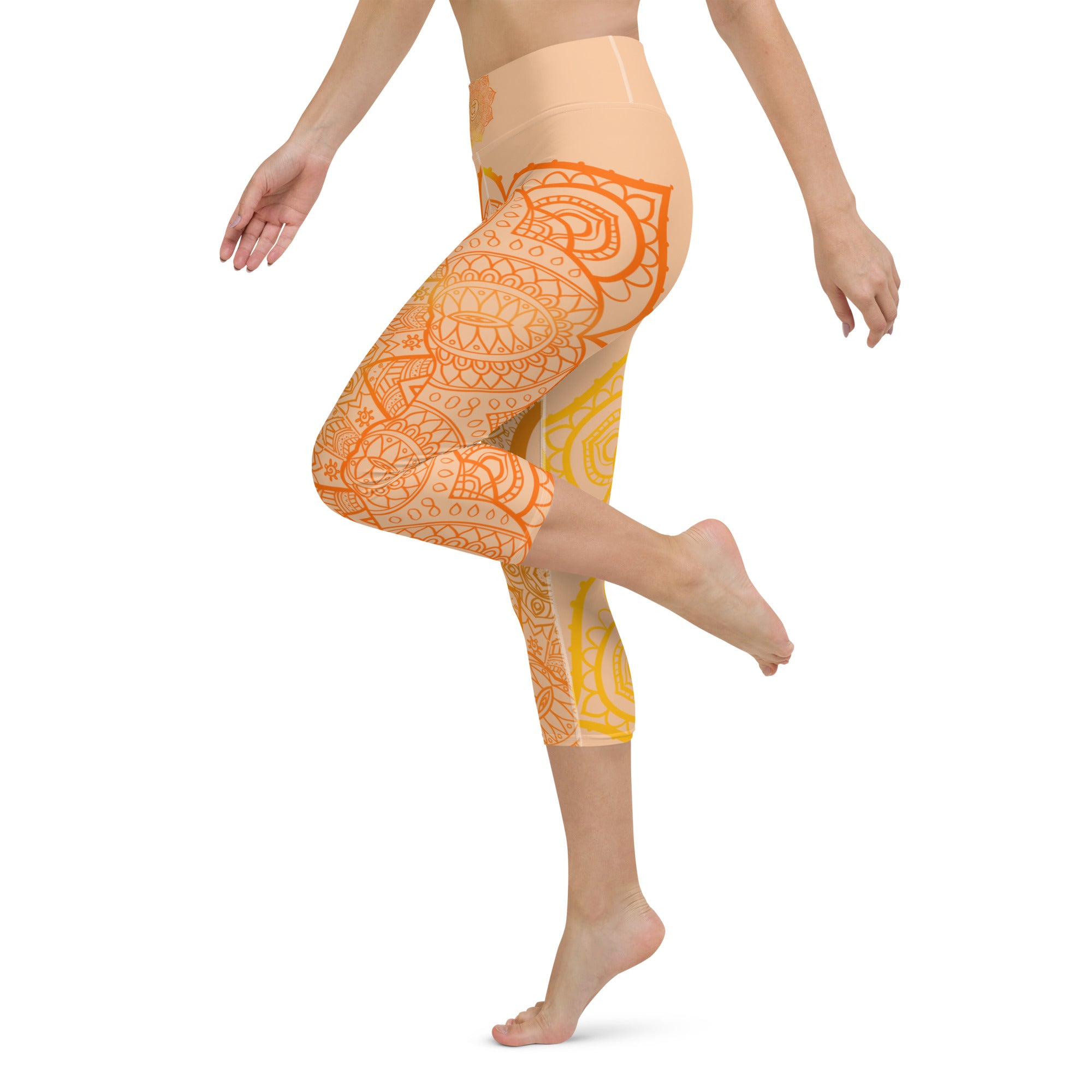 yoga capri leggings by goddess swag. Design is a sacral chakra mandala on front and back of leggings in deep orange and light yellow coloring.  Back waist has goddess swag written in light gold. mid calf legging length.