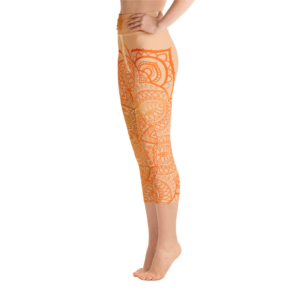 yoga capri leggings by goddess swag. Design is a sacral chakra mandala on front and back of leggings in deep orange and light yellow coloring.  Back waist has goddess swag written in light gold. mid calf legging length.