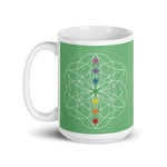 Load image into Gallery viewer, Jade heart chakra ceramic coffee mug design is a green background with sacred geometry and all seven chakras.  coffee mug is 15 ounces. By goddess swag
