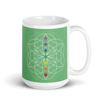 Load image into Gallery viewer, Jade heart chakra ceramic coffee mug design is a green background with sacred geometry and all seven chakras.  coffee mug is 15 ounces. By goddess swag
